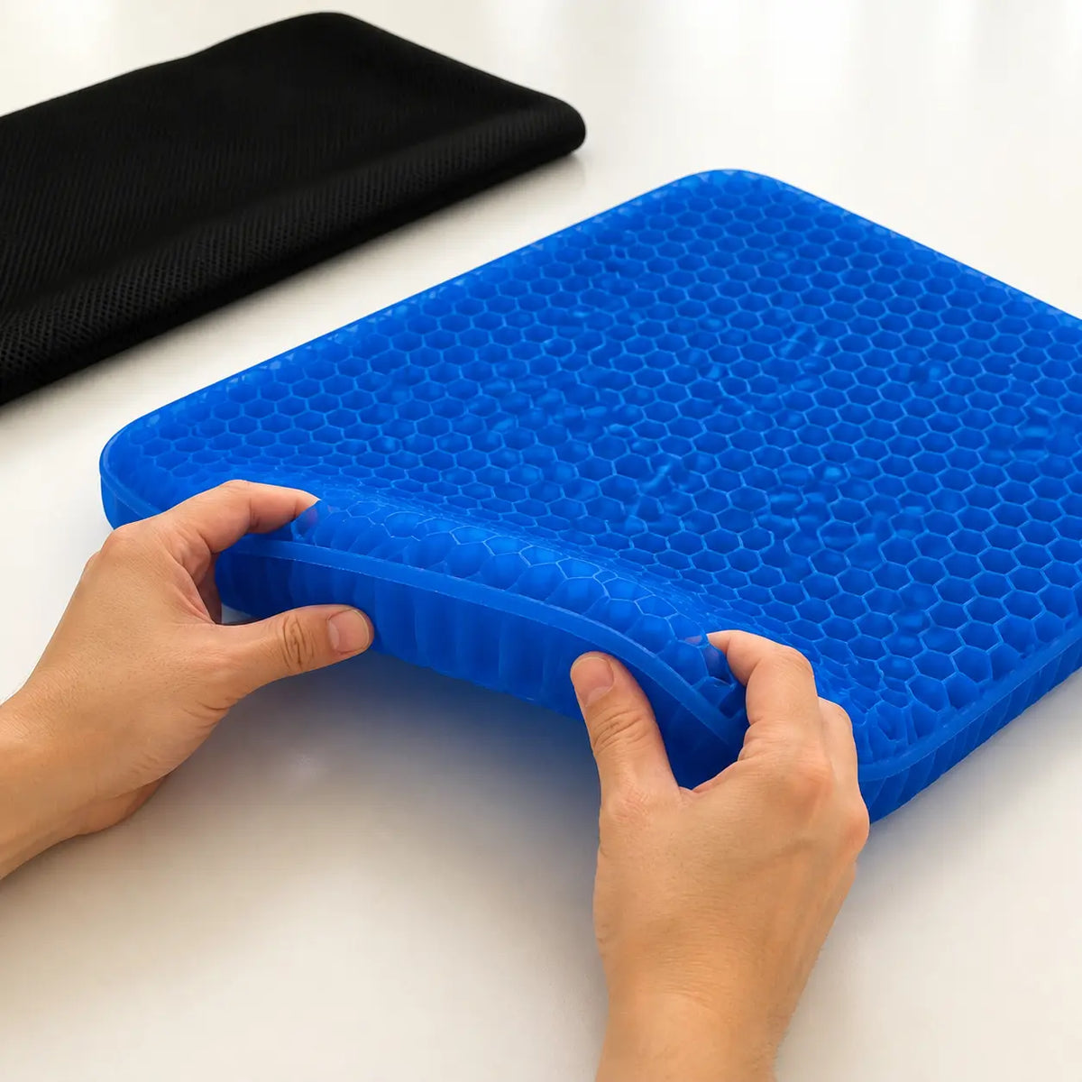 Hands compressing the flexible gel structure of the GlowTales seat cushion.