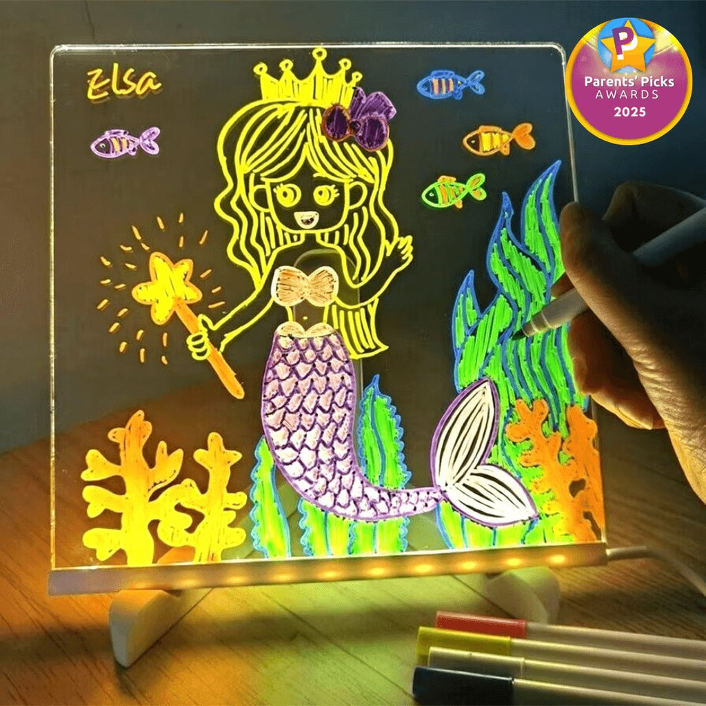 Child drawing a glowing neon mermaid on the LED drawing board